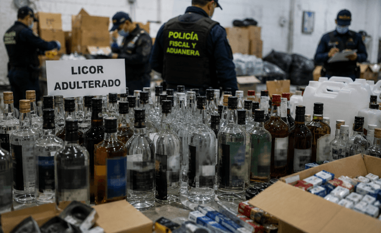 Botellas de licor adulterado incautadas durante un operativo de la Policía Fiscal y Aduanera en Medellín contra el contrabando y la fabricación ilegal de bebidas alcohólicas.